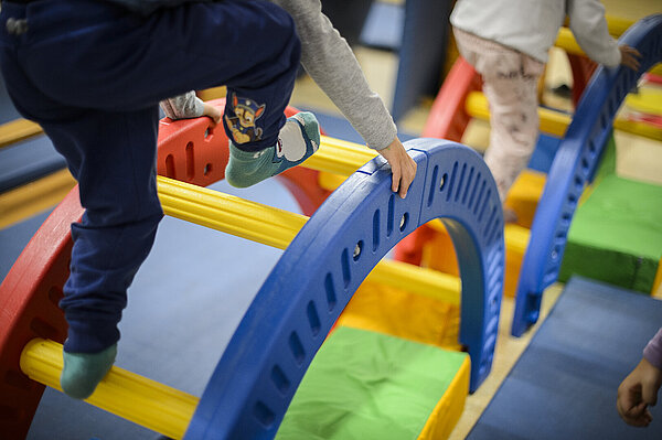 Kind klettert über Spielbögen