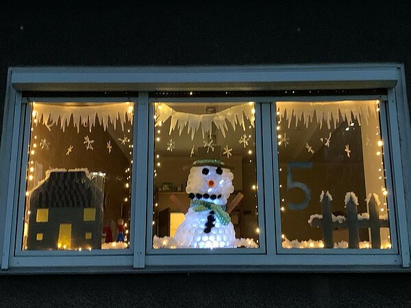 Dekoriertes Fenster mit Schneemann und Lichterketten