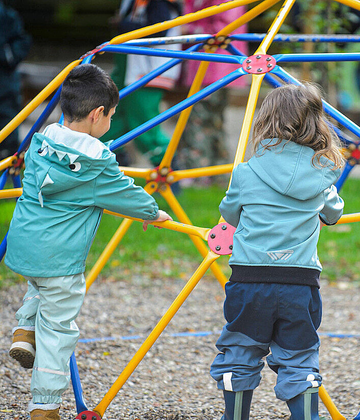 Kinder spielen an einem Klettergerüst